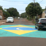 Moradores pintam bandeira gigante do Brasil na rua no bairro Tijuca II, Campo Grande.