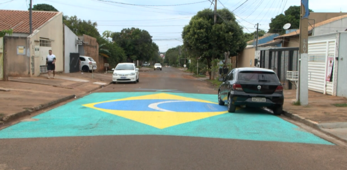 Moradores pintam bandeira gigante do Brasil na rua no bairro Tijuca II, Campo Grande.