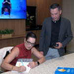 Delegada Aline Sinnott autografando seu livro "A Jornada dos Esquecidos" em evento em Campo Grande.