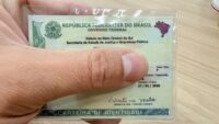 Pessoas em fila para emitir a nova carteira de identidade nacional em Campo Grande durante mutirão.